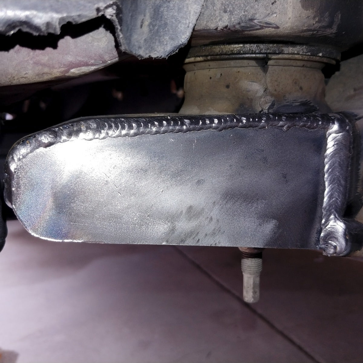 Close view of welded chop plate closing the body mount