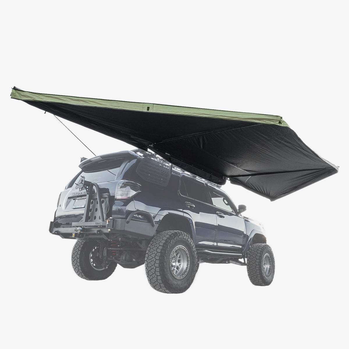 Black and green 180° awning deployed beside a dark SUV with a roof rack