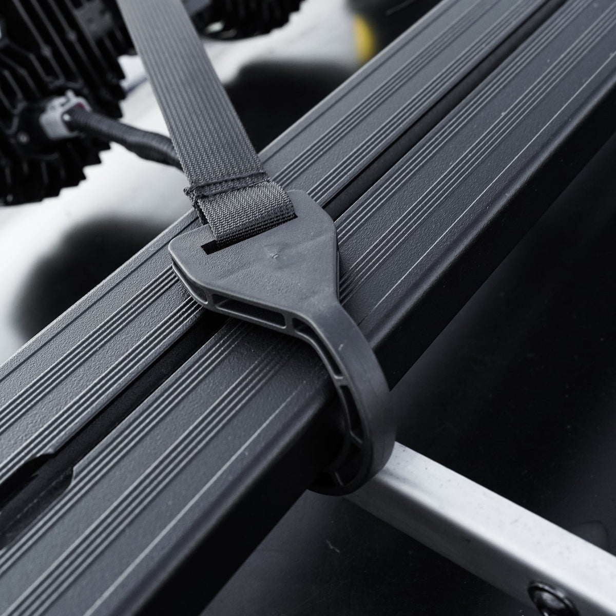 Strap secured around the awning mounting rail