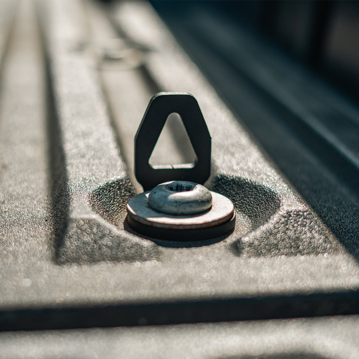 Cali Raised LED bed tie down installed in a truck bed anchor point, straight-on close-up