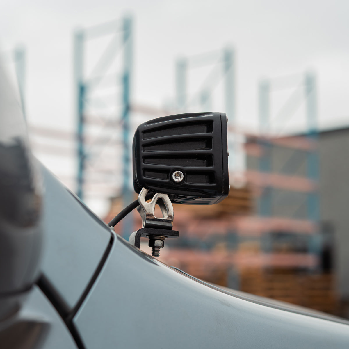 Side view of a ditch light pod on its bracket at the edge of the hood