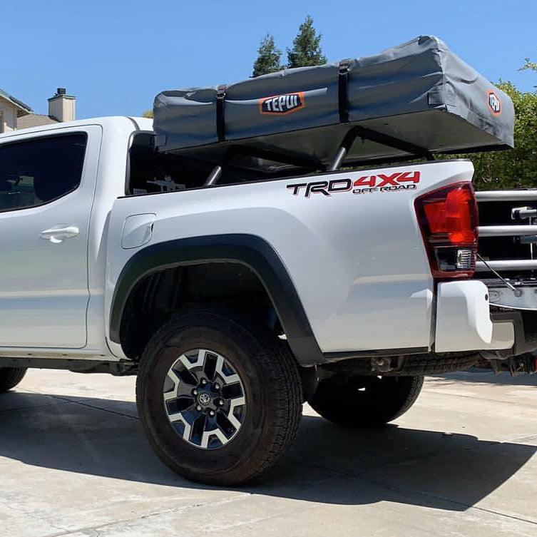 White Tacoma TRD 4x4 with rooftop tent on HMOR bed bars, rear quarter view