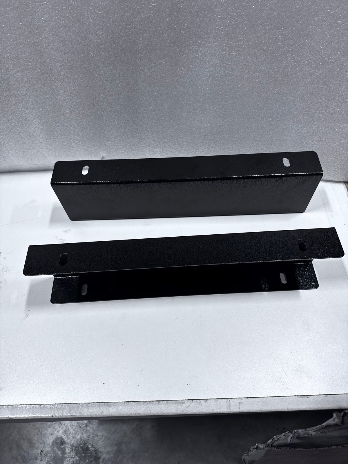 Pair of Mid Deck riser brackets on a white bench