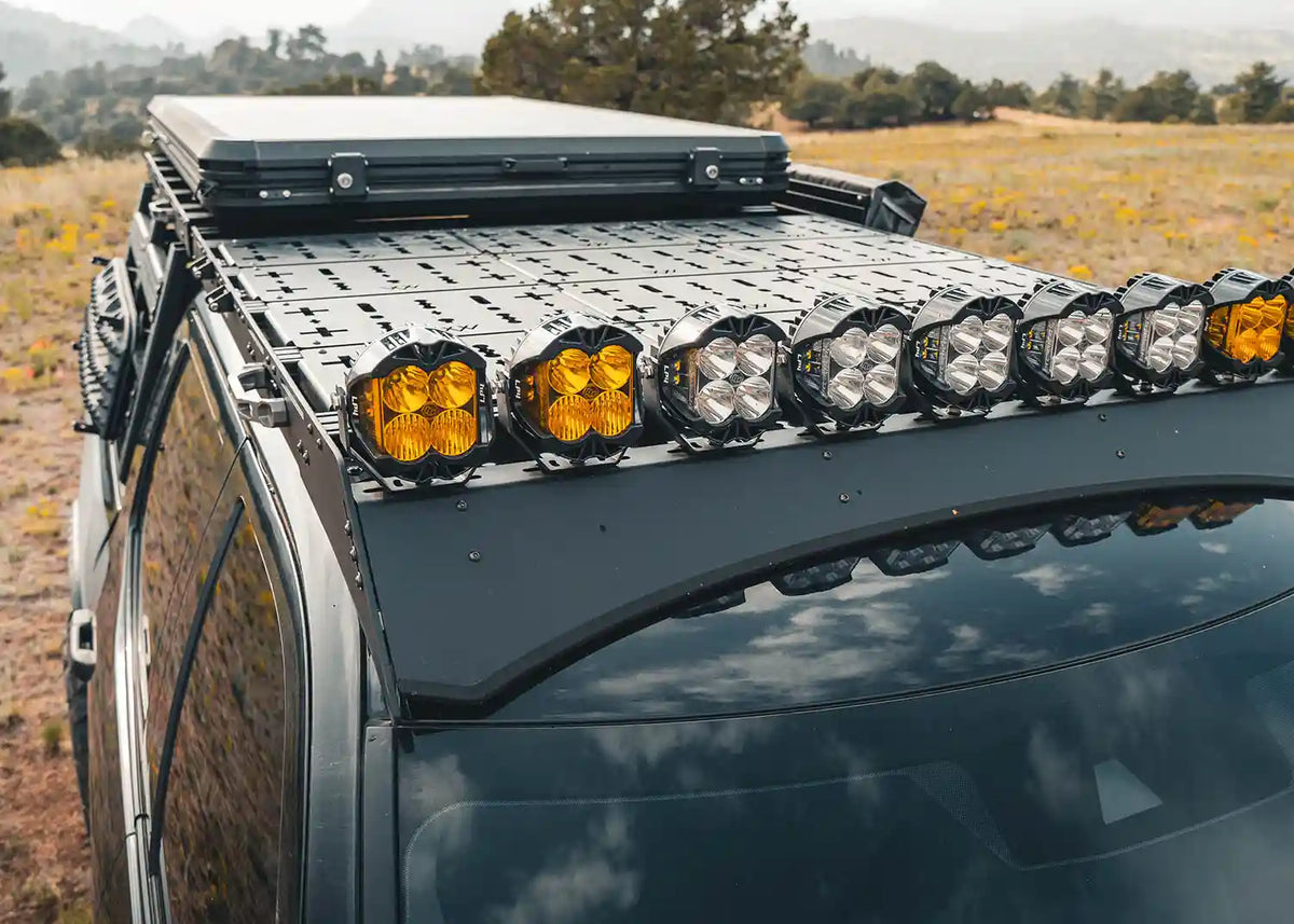 DRIFTR Toyota Tundra roof rack loaded with a rooftop tent, storage box, and mounted accessories in a field