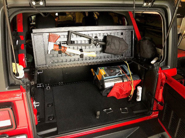 Folding top MOLLE panel under a raised Slipstream top holding an axe and shovel in a red Jeep