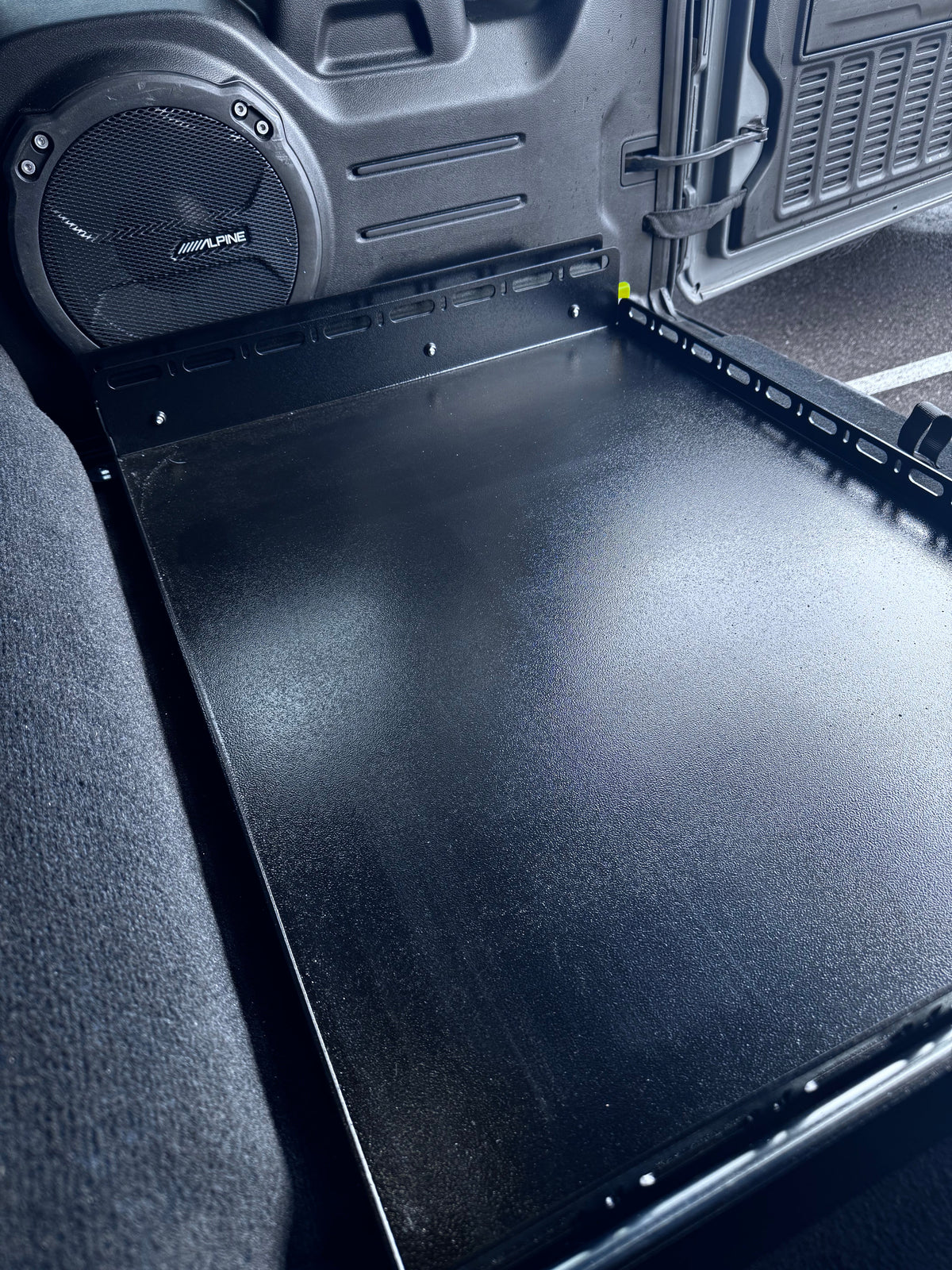 Slide Floor 2.0 beside an aftermarket subwoofer in a JLU