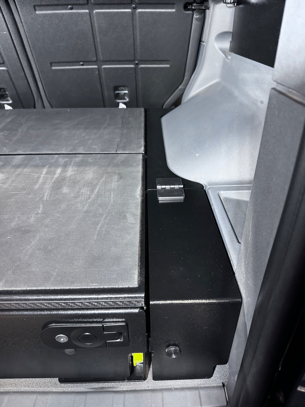 Leveling panel hinged rear section opening to the Grenadier side cubby