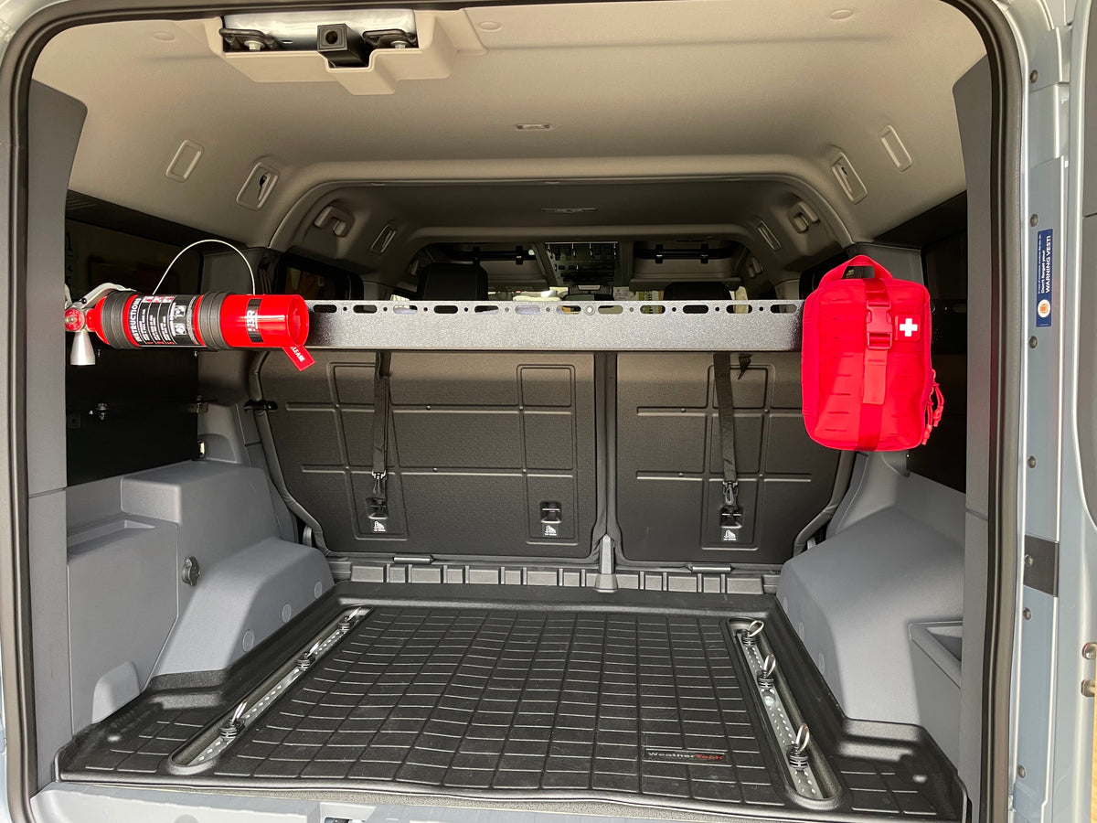 Grenadier cargo area with a crossbar holding a fire extinguisher and first-aid kit