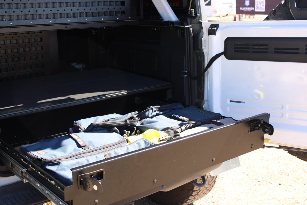 Bronco complete drawer system extended from a white Bronco with a gear bag on the tray