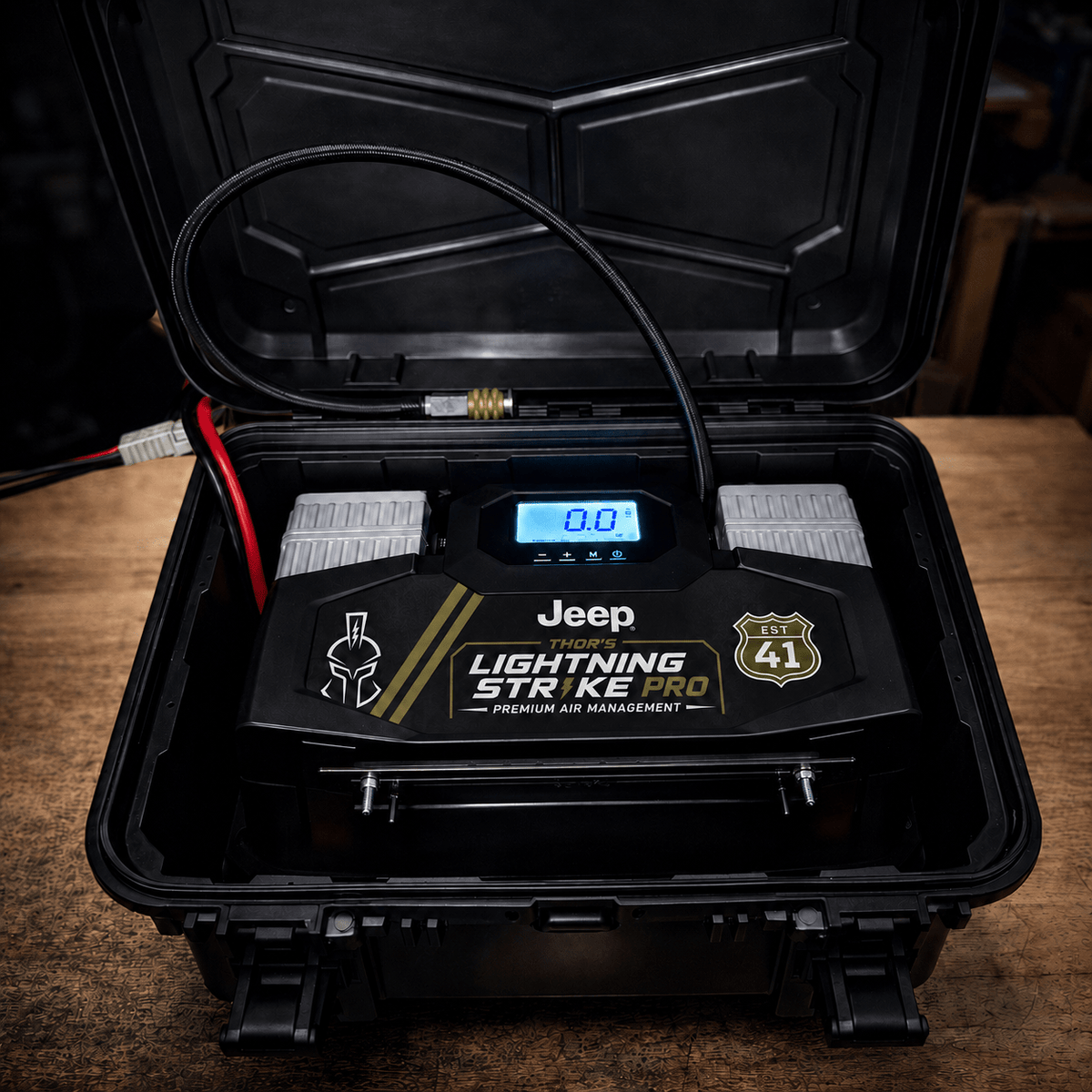 AirVault StrikePro with Jeep faceplate in its open hard case, photographed on a wood workbench