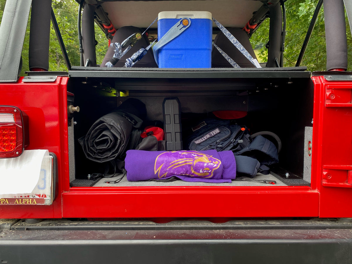 Red TJ tailgate open showing gear stored inside the Ridgeback, cooler on top