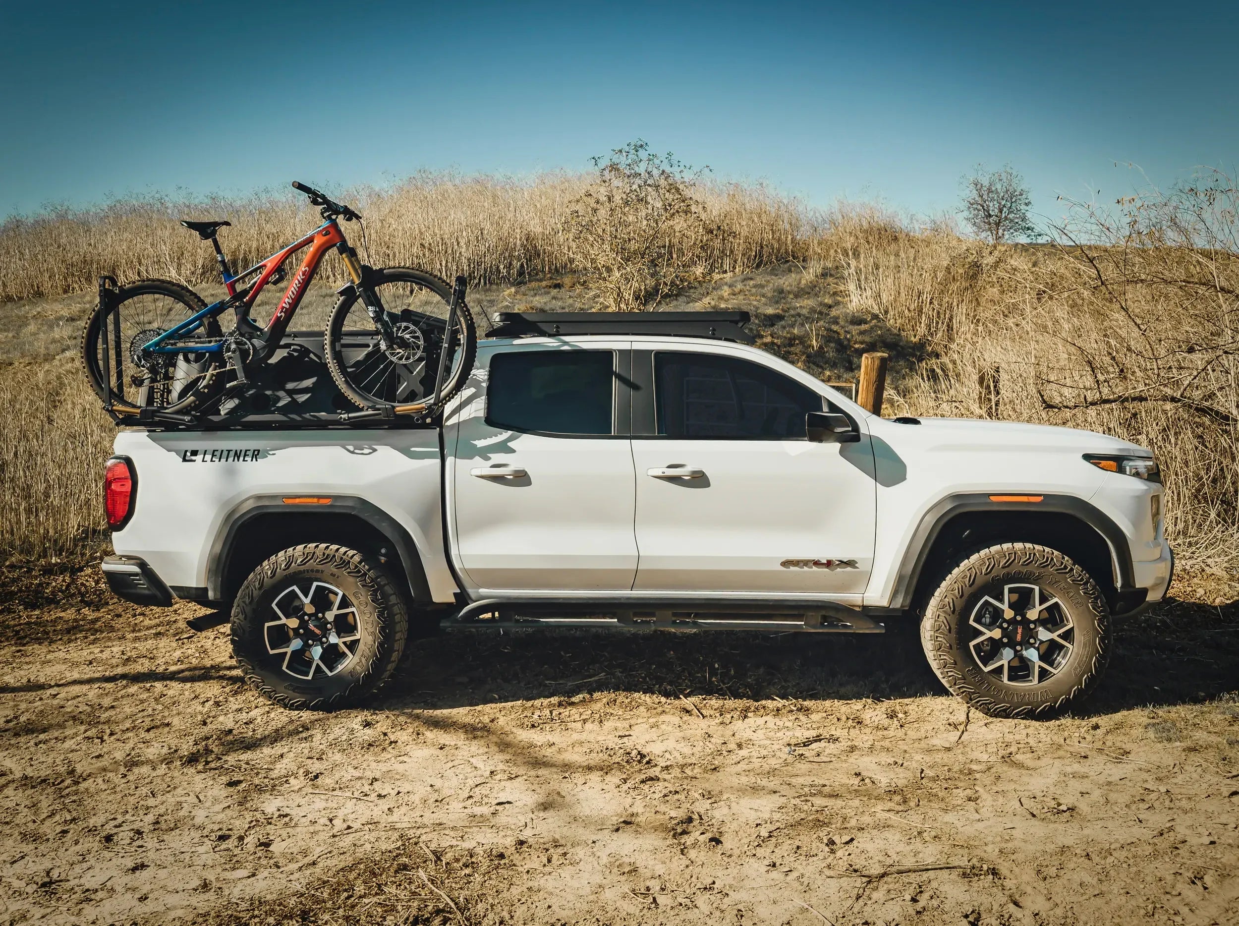 SIDE VIEW OF WHITE GMC TRUCK WITH BIKE MOUNTED