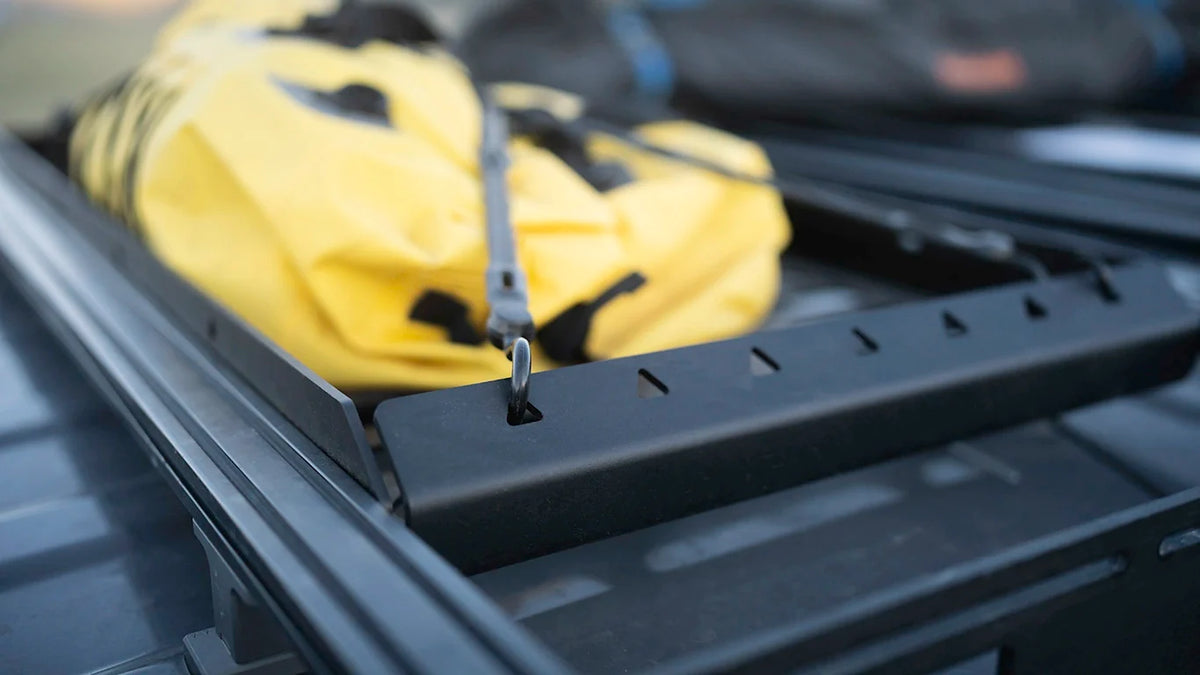 Yellow dry bag secured in the Roof Rack Storage Basket mounted on a roof rack, alternate angle
