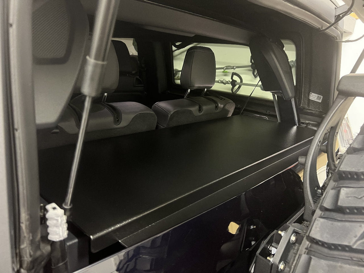 Locker lid propped open on a strut in a Bronco 2-door, rear seats behind