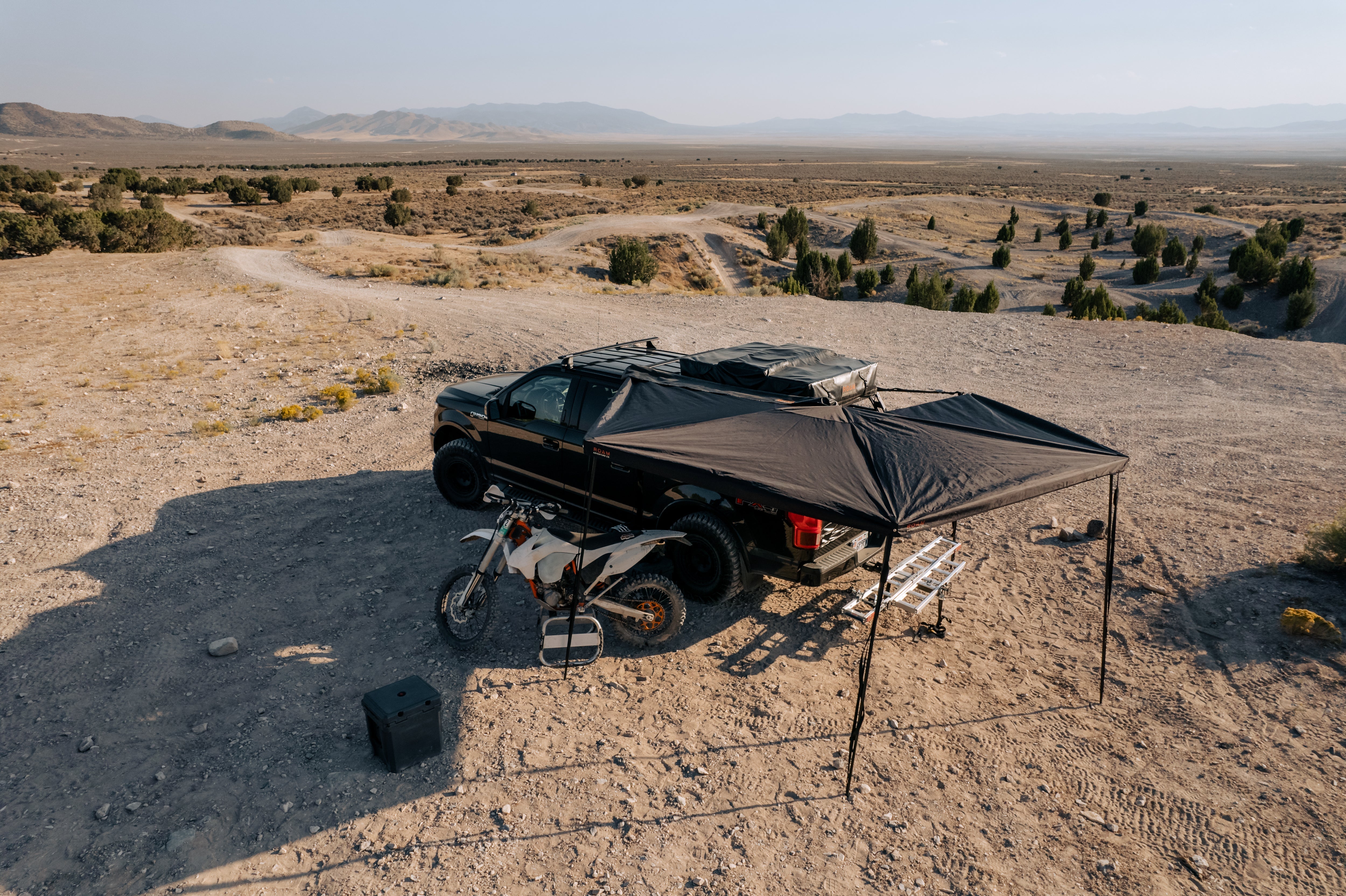 Aerial view of a ROAM ARC 270 awning covering a campsite