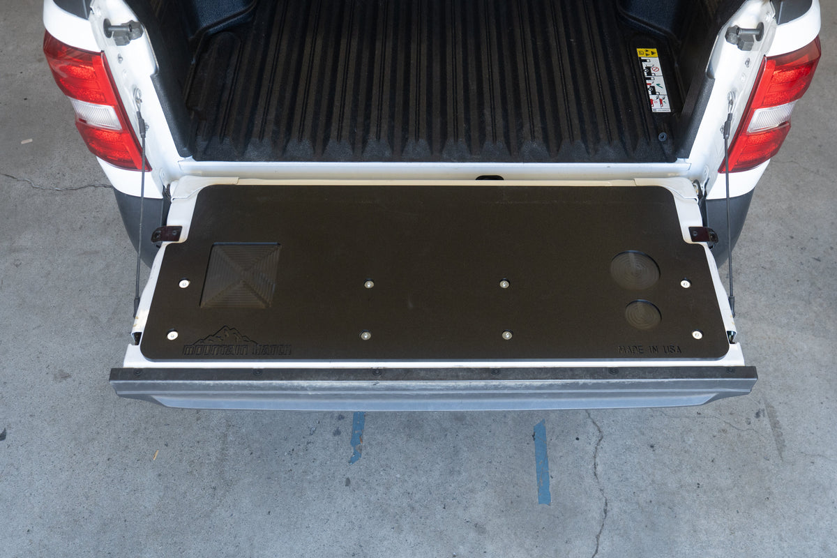 Straight-on view of a Ford Maverick tailgate with the Mountain Hatch panel installed, drink holders at right