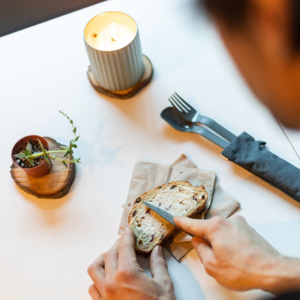 Small candle and plate with a utensil, close-up of a cozy table setting