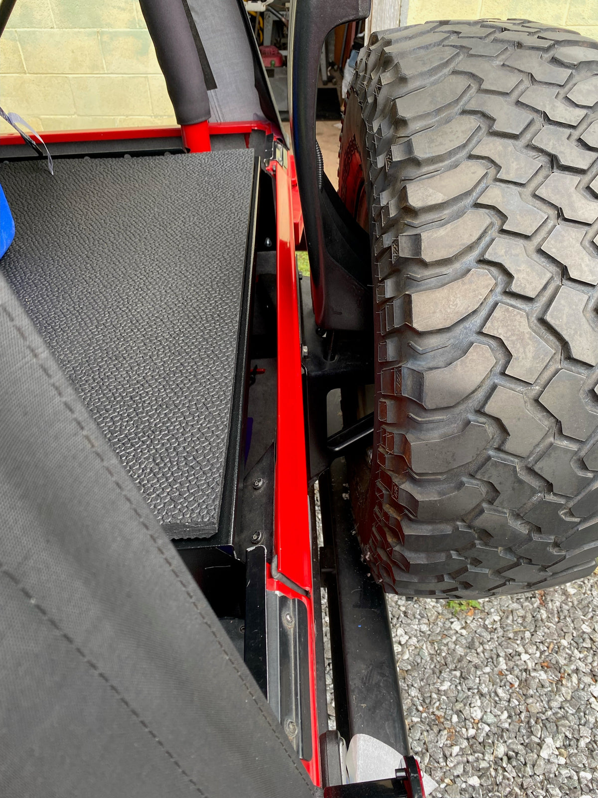 Ridgeback top beside the spare tire on a red TJ