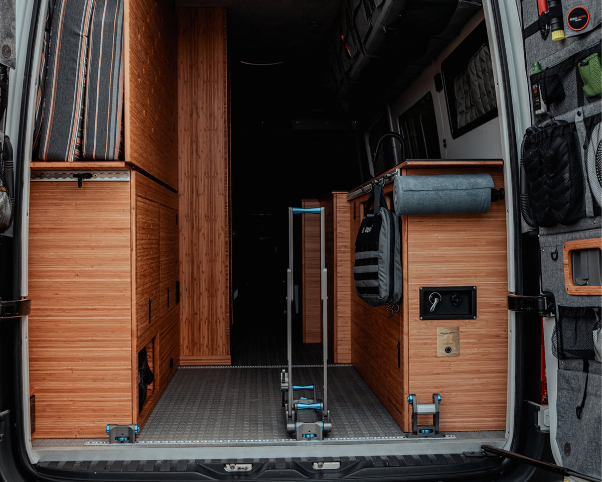 HOVR rack installed on L-track in a van with wood-paneled walls