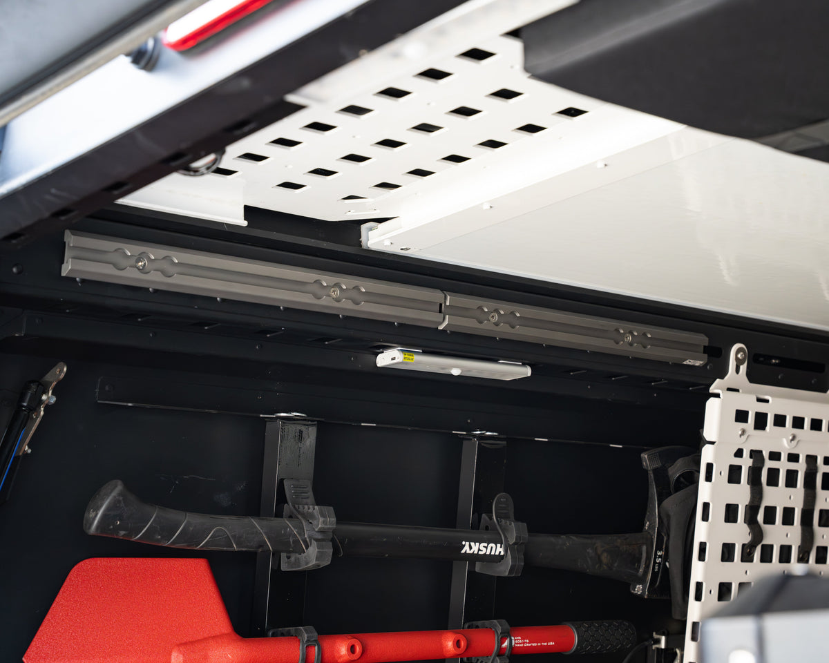 Freedom Track rails installed inside a Super Pacific camper holding tools on MODmounts
