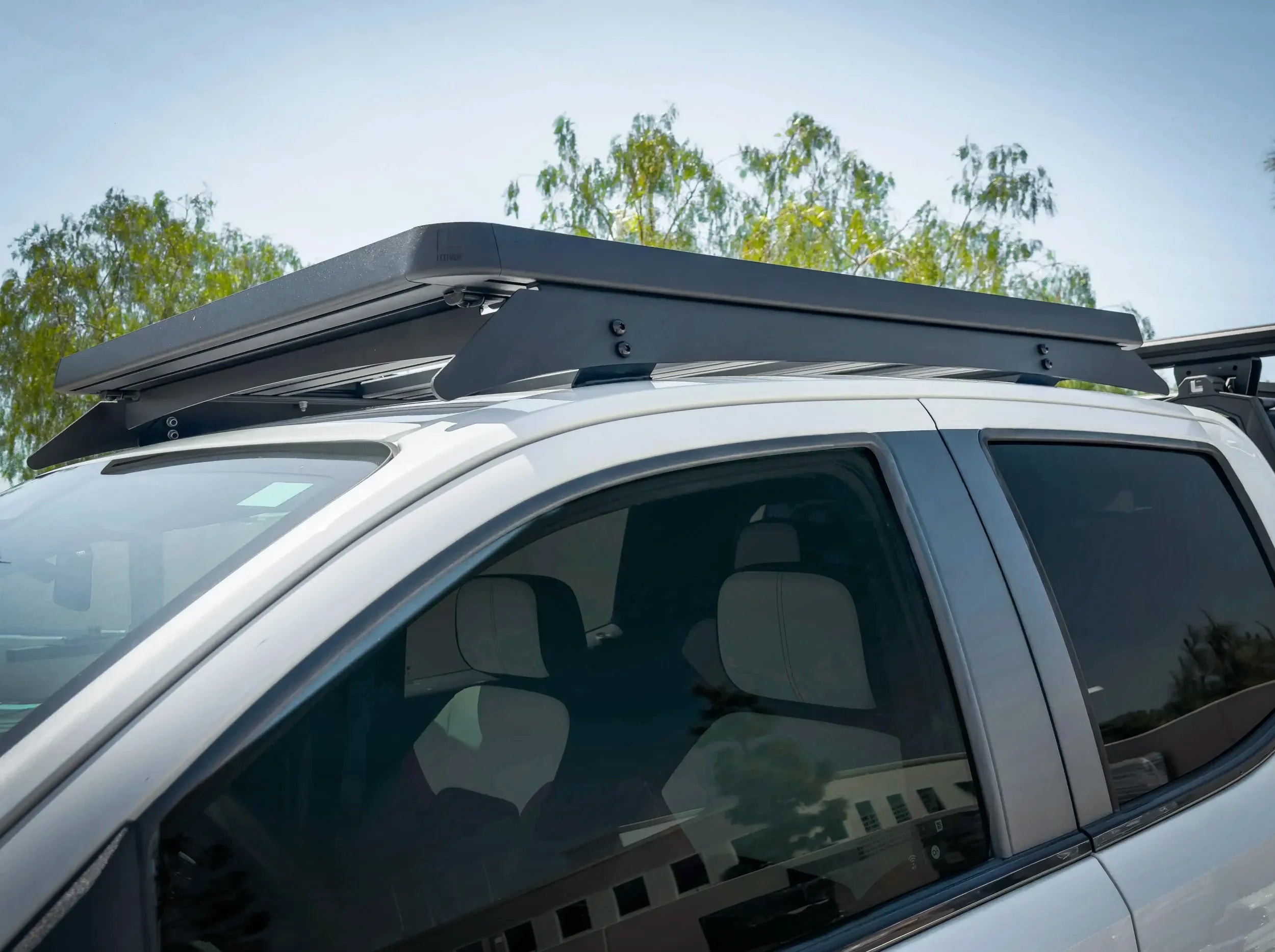 CLOSE UP VIEW OF ACS ROOF RACK MOUNTED ON WHITE GMC CANYON RACK