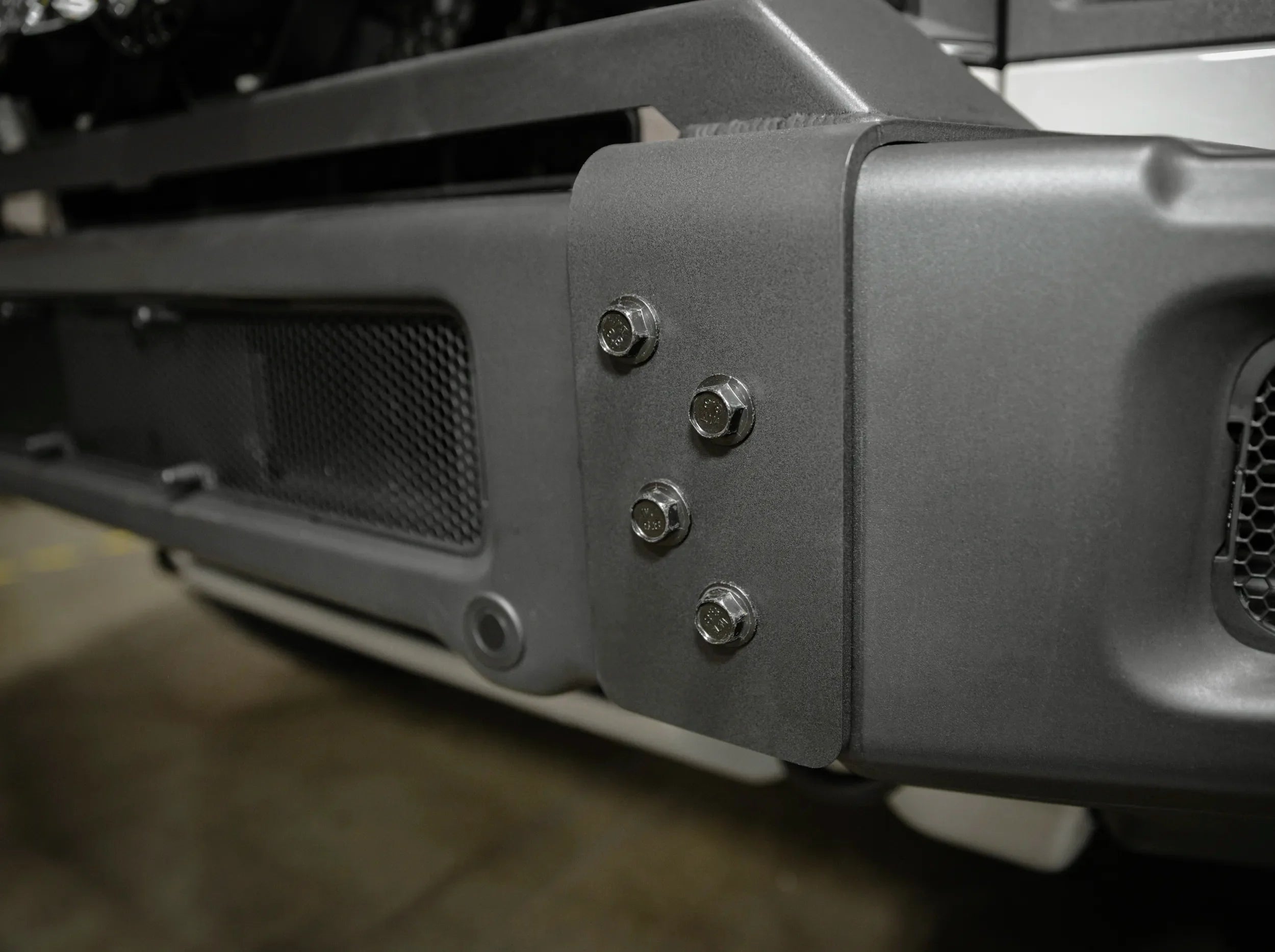 CLOSE UP VIEW OF BOLTS SECURED FOR FRONT BUMPER ON GRENADIER