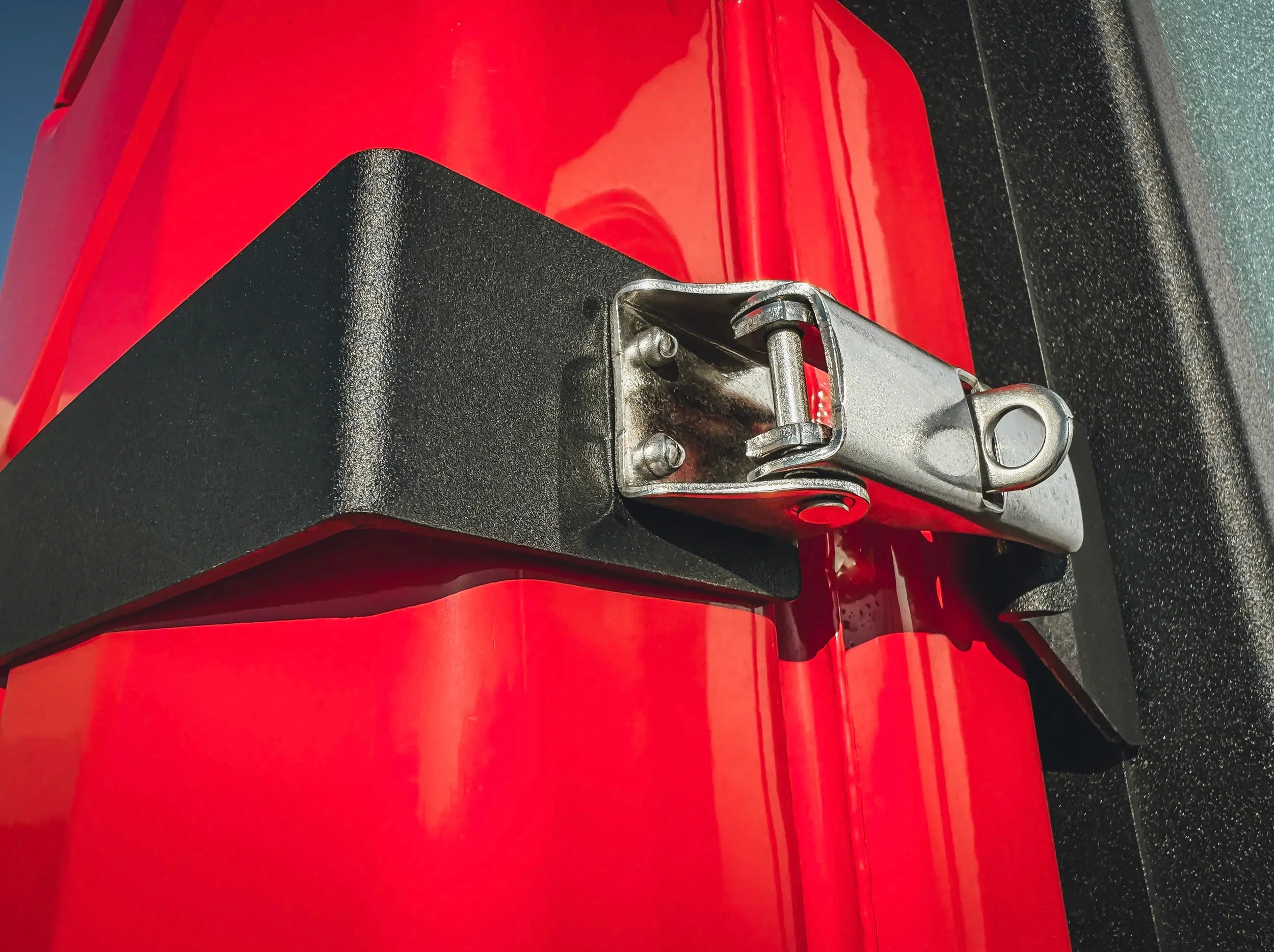 CLOSE UP VIEW OF SECURE LATCH ON JERRY CAN HOLDER
