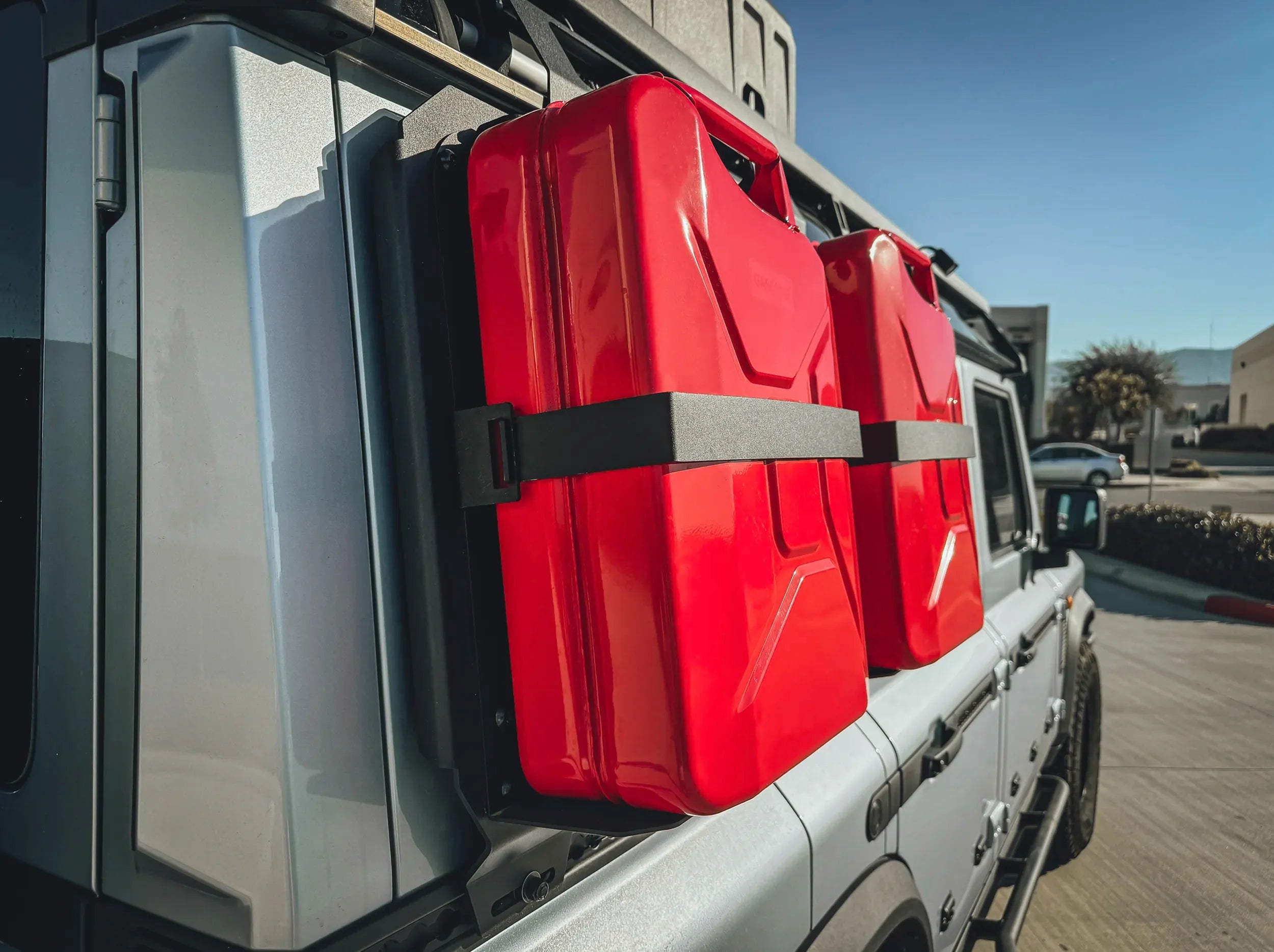 CLOSE UP VIEW OF JERRY CANS HELD IN JERRY CAN HOLDER MOUNTED TO SIDE KICK PANEL FOR INEOS GRENADERI