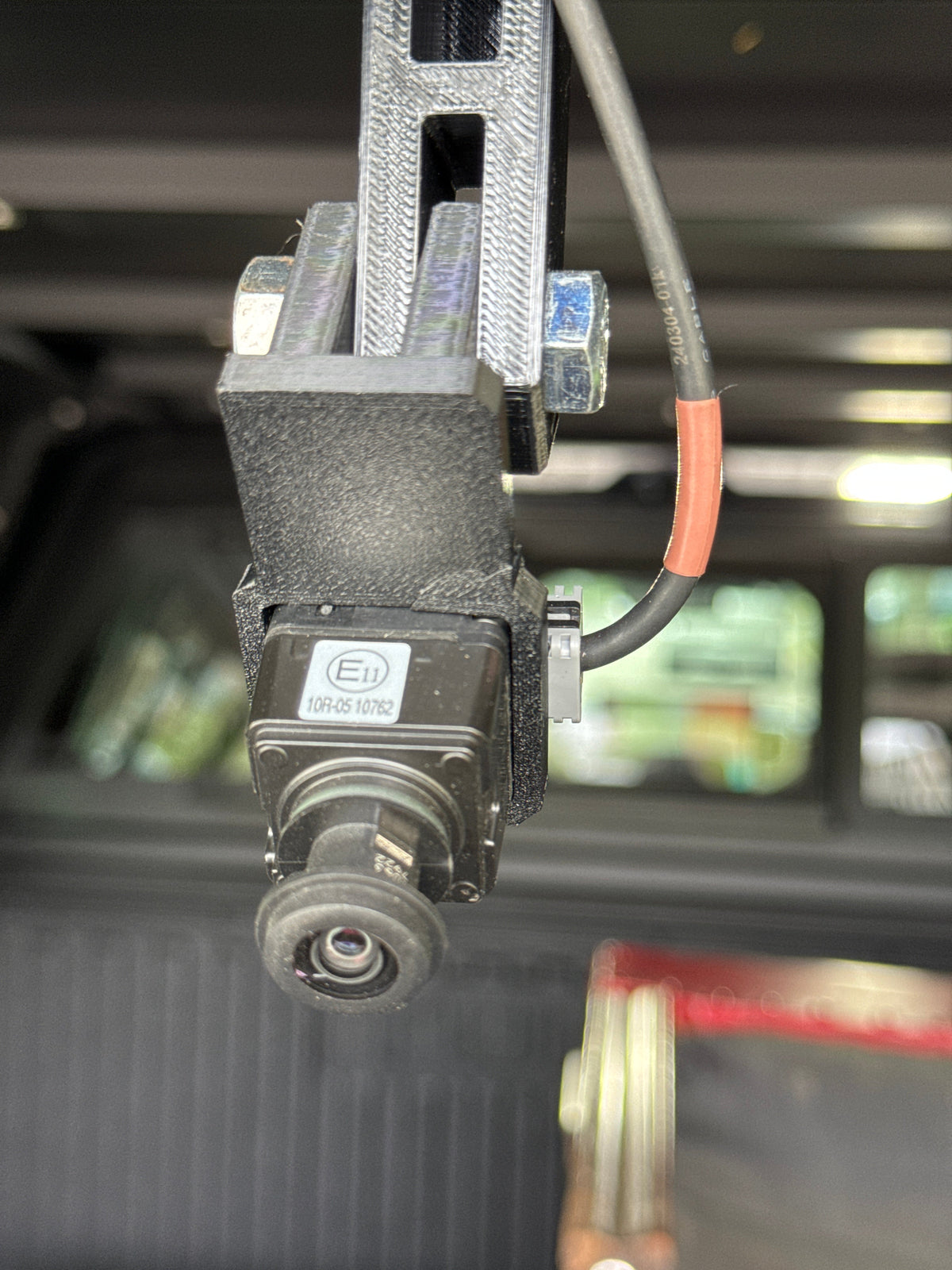 Factory Toyota camera clipped into the GG Offroad pivot arm under a topper roof