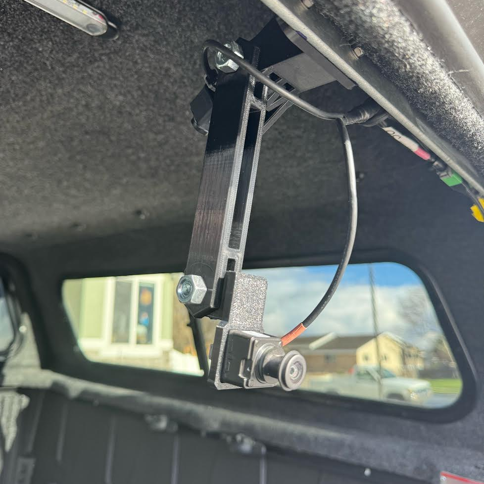 GG Offroad pivot arm mount aiming a camera through the topper rear glass