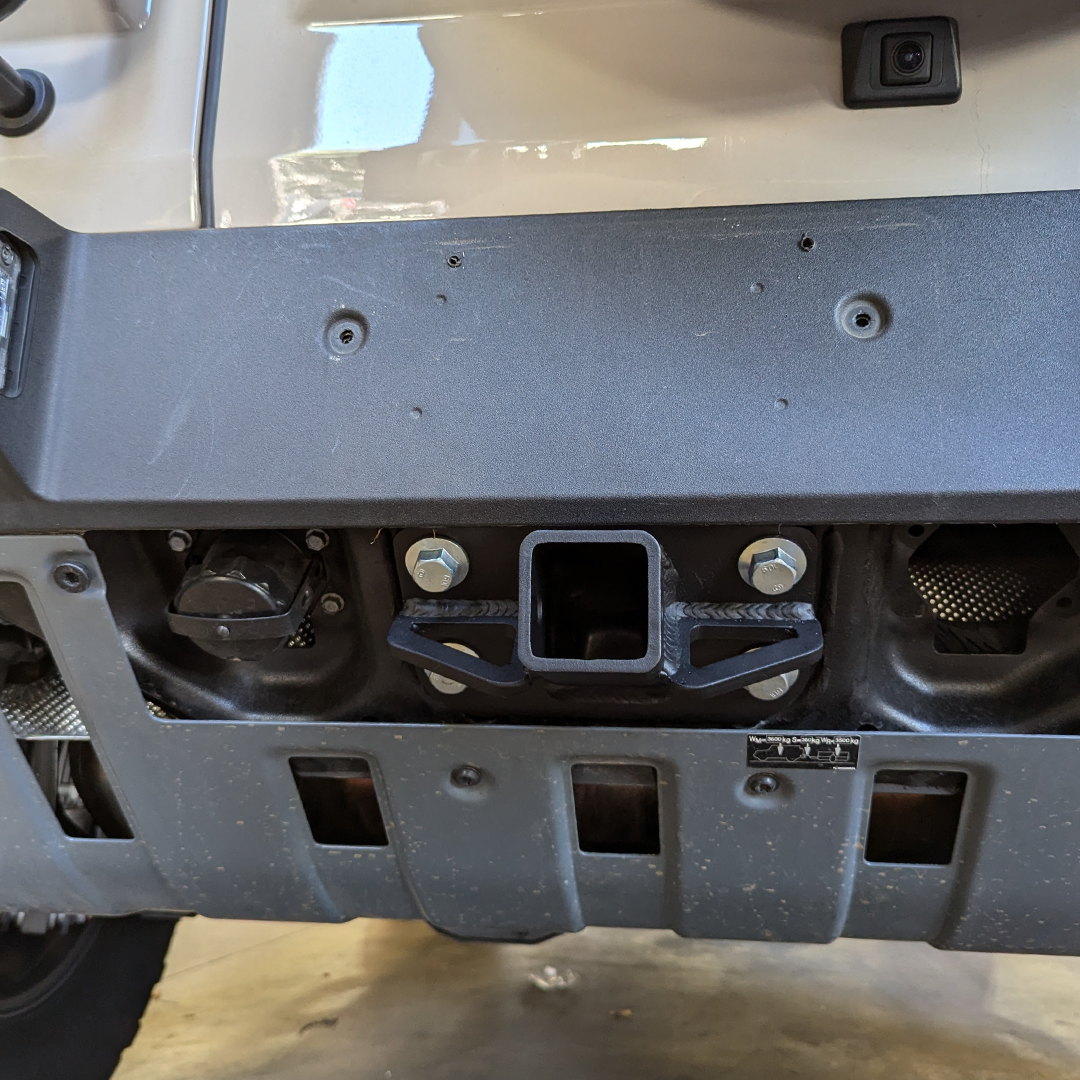 Installed hitch receiver below the rear bumper, seen from underneath