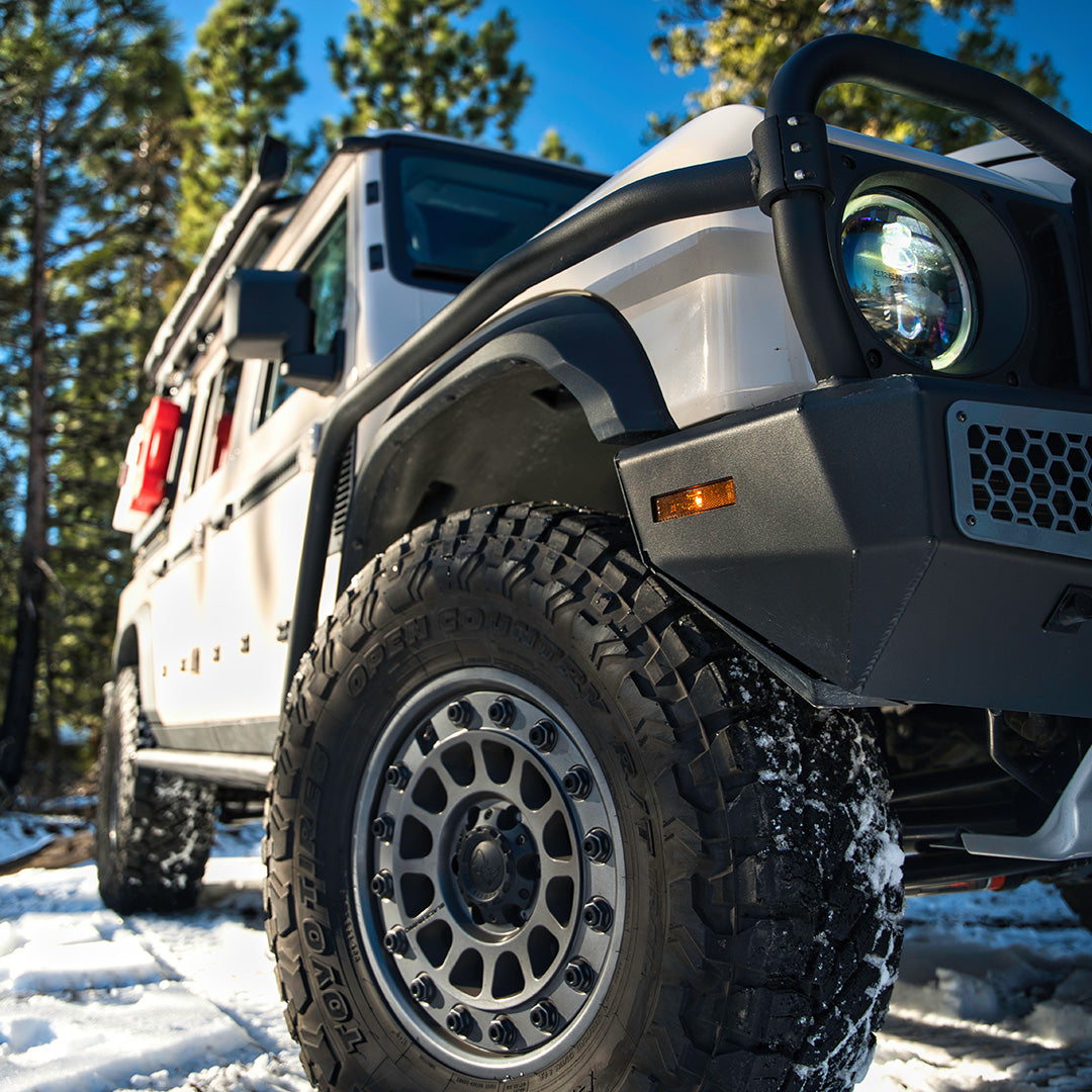 Close view of the bull bar above a wheel and tire in snow