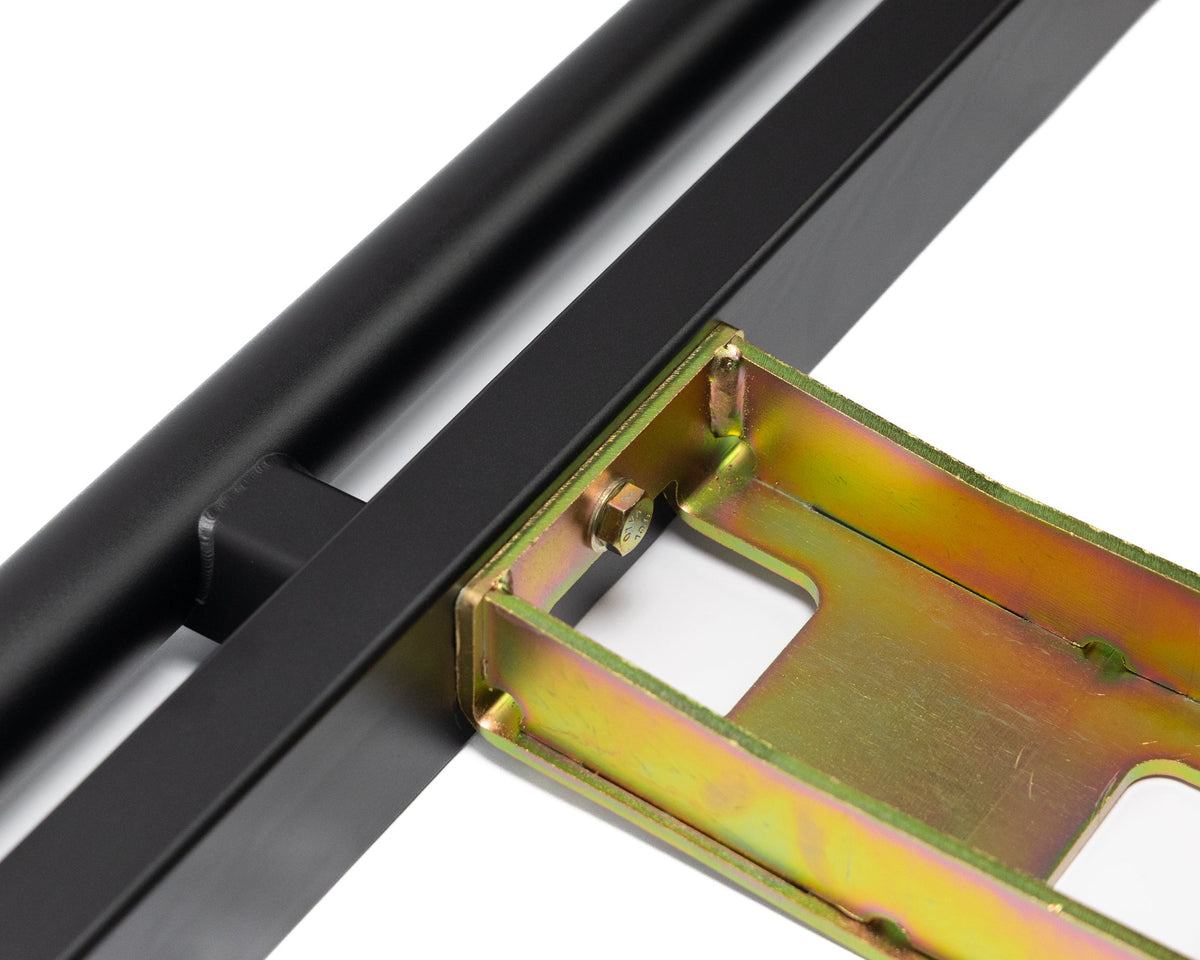 Rock slider tube joined to a yellow zinc mounting bracket, close-up