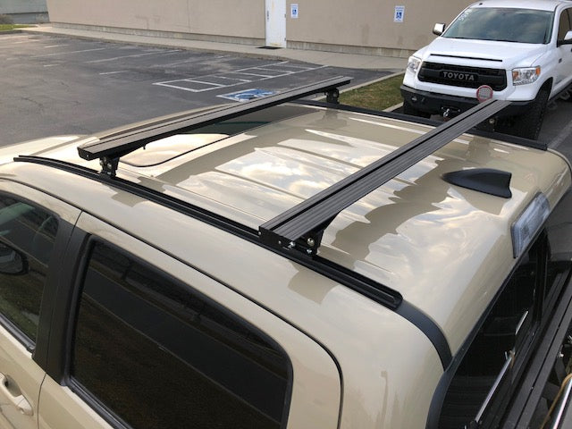 Eezi-Awn K9 load bars on a crew cab roof, rear three-quarter view