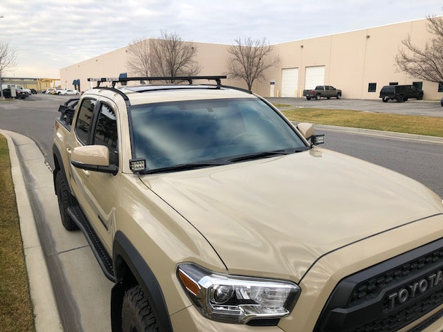 Eezi-Awn K9 load bars on a Toyota pickup roof, front view
