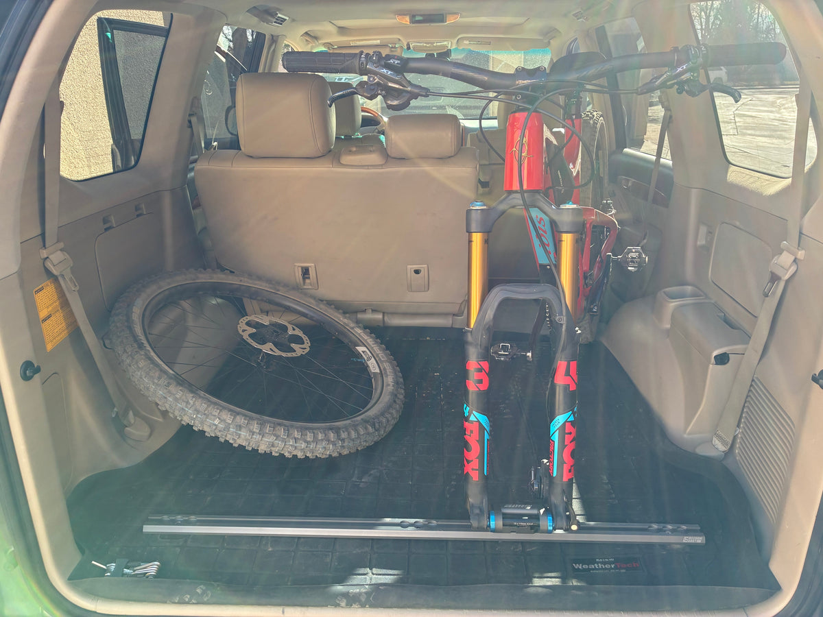 Lexus GX470 cargo area with Freedom Track installed and a mountain bike held by a fork mount