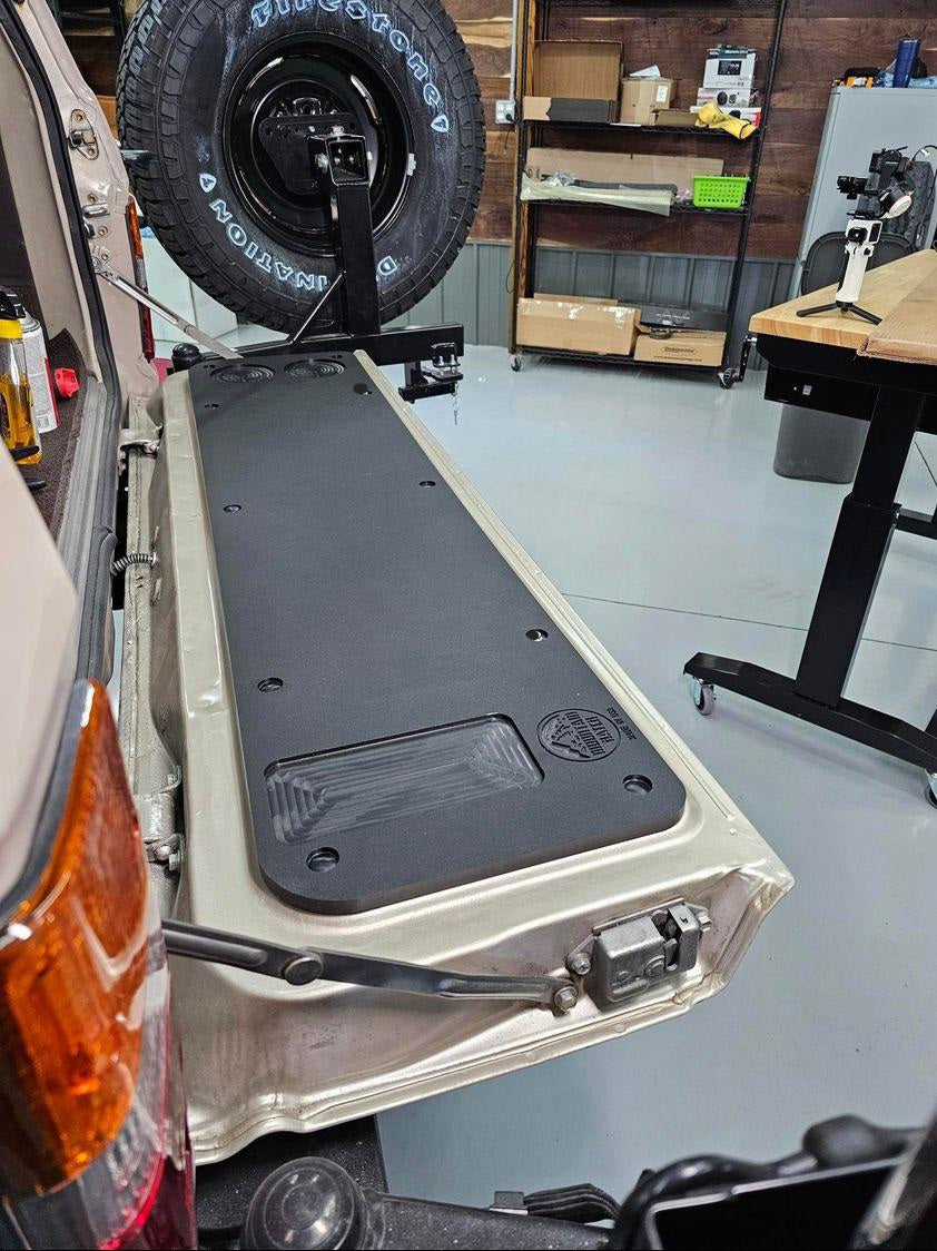 Mountain Hatch tailgate table installed on a Toyota Land Cruiser 60 Series rear tailgate with swing-out spare tire above