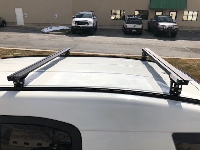Eezi-Awn K9 load bars on a white vehicle roof
