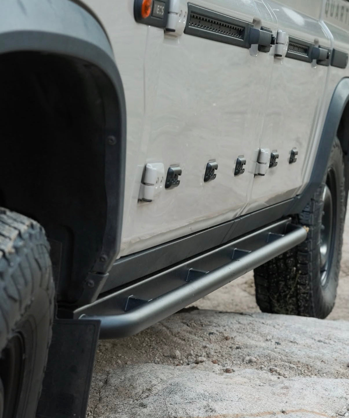 GP Factor rock slider kit installed on an INEOS Quartermaster on rocky terrain