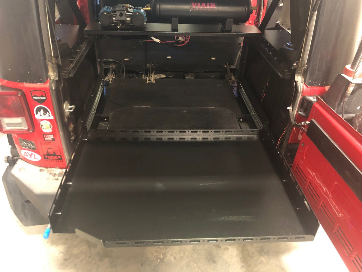 Slide floor fully extended out the back of a red Jeep JKU