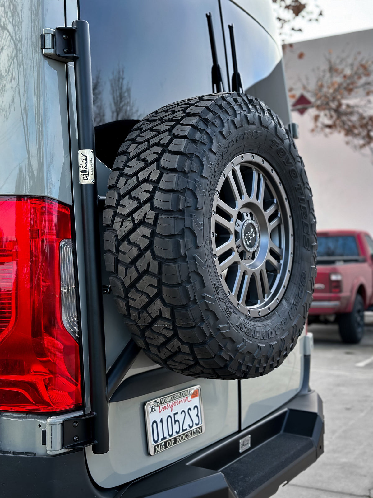 Spare tire mounted on the carrier on the rear door of a van