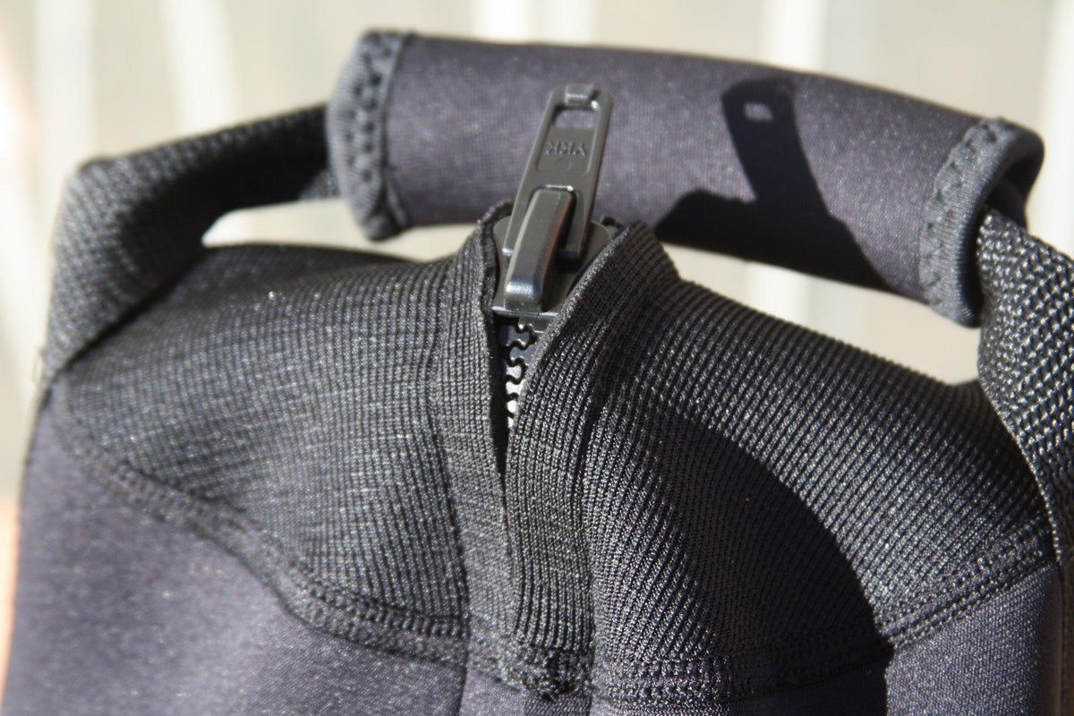 Close-up of a black neoprene bag's padded handle and zipper pull