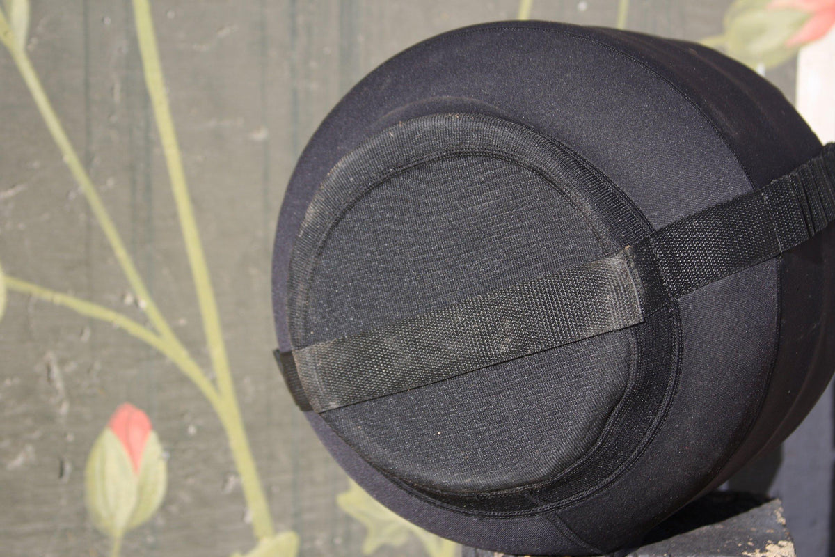 Close-up of a black neoprene tank top propane cylinder cover's rounded base and nylon strap
