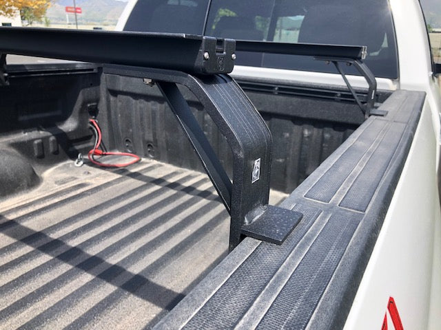 K9 bed rail leg saddling the bed rail of a pickup