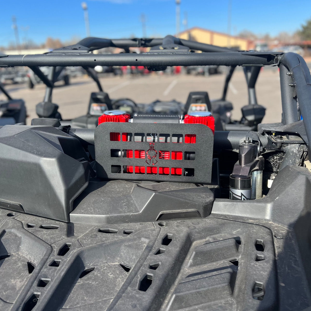 Two red 12V compressors hard-mounted in a Refuge MOLLE bracket on a side-by-side's rear cage, real install photo