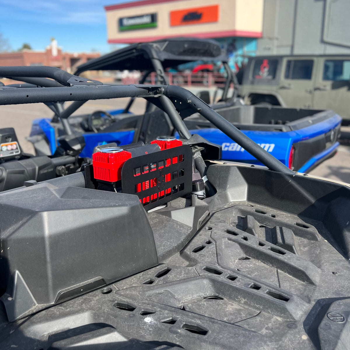 Refuge MOLLE mount with two red 12V compressors installed, viewed from the driver's seat looking back