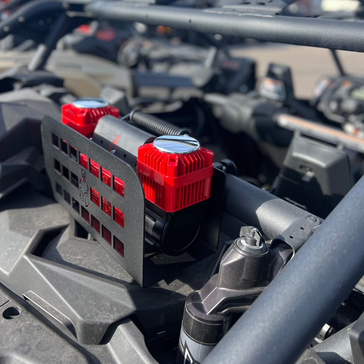 Close-up of two red 12V compressors mounted side by side in the Refuge MOLLE bracket with wiring visible