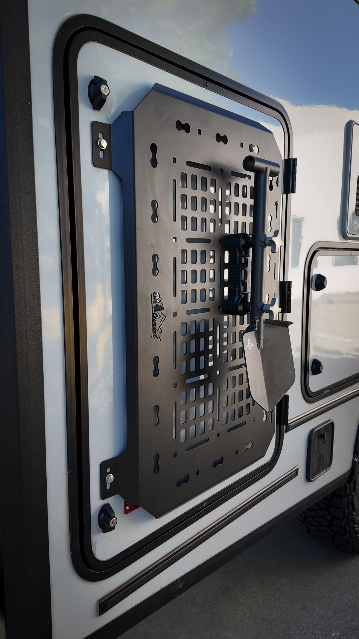 Black MOLLE panel mounted on the door of a van