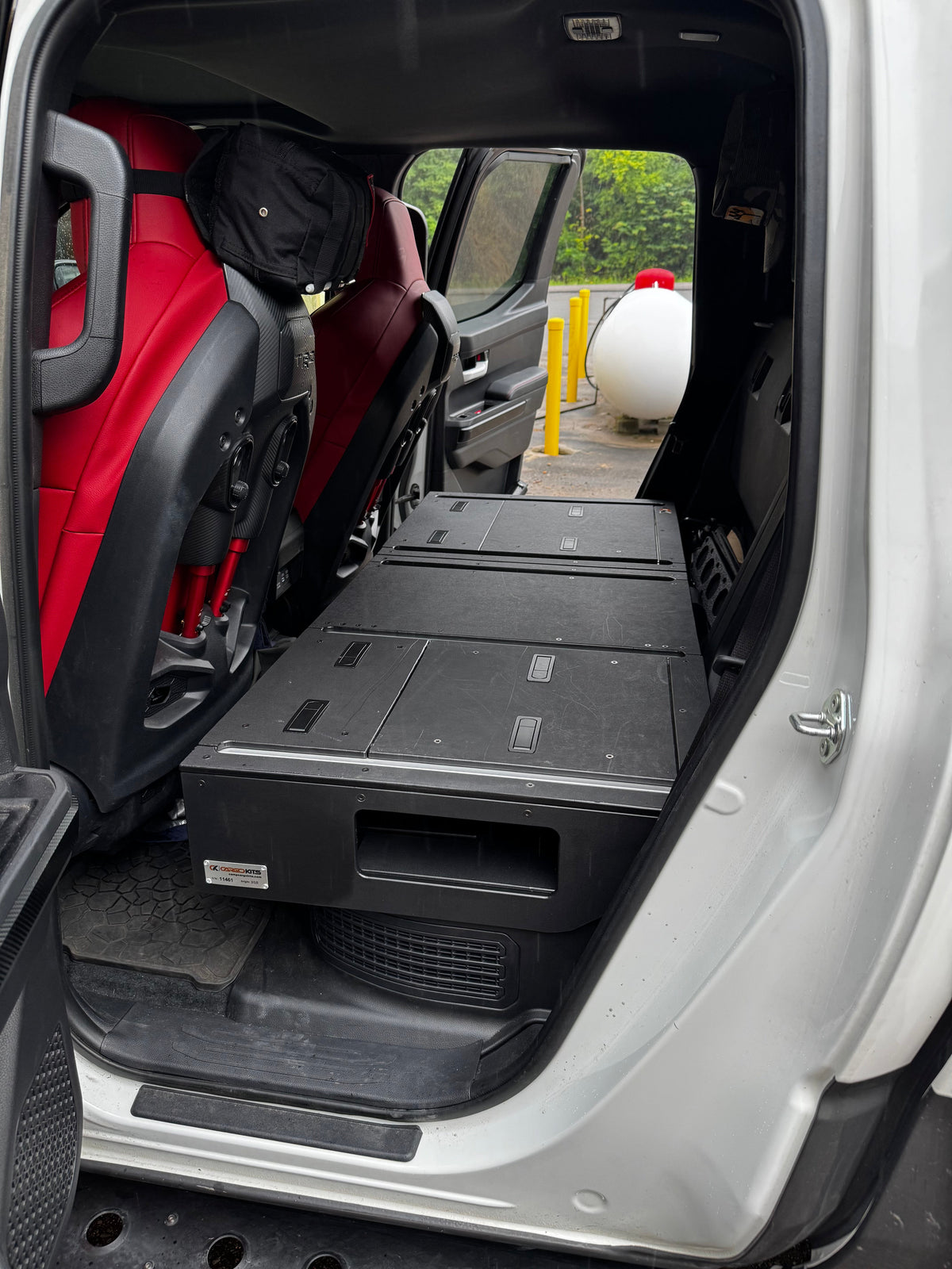 CargoKits Rear Seat Delete in a Tacoma TRD Pro Hybrid, close-up of the platform's access hatch and rail hardware
