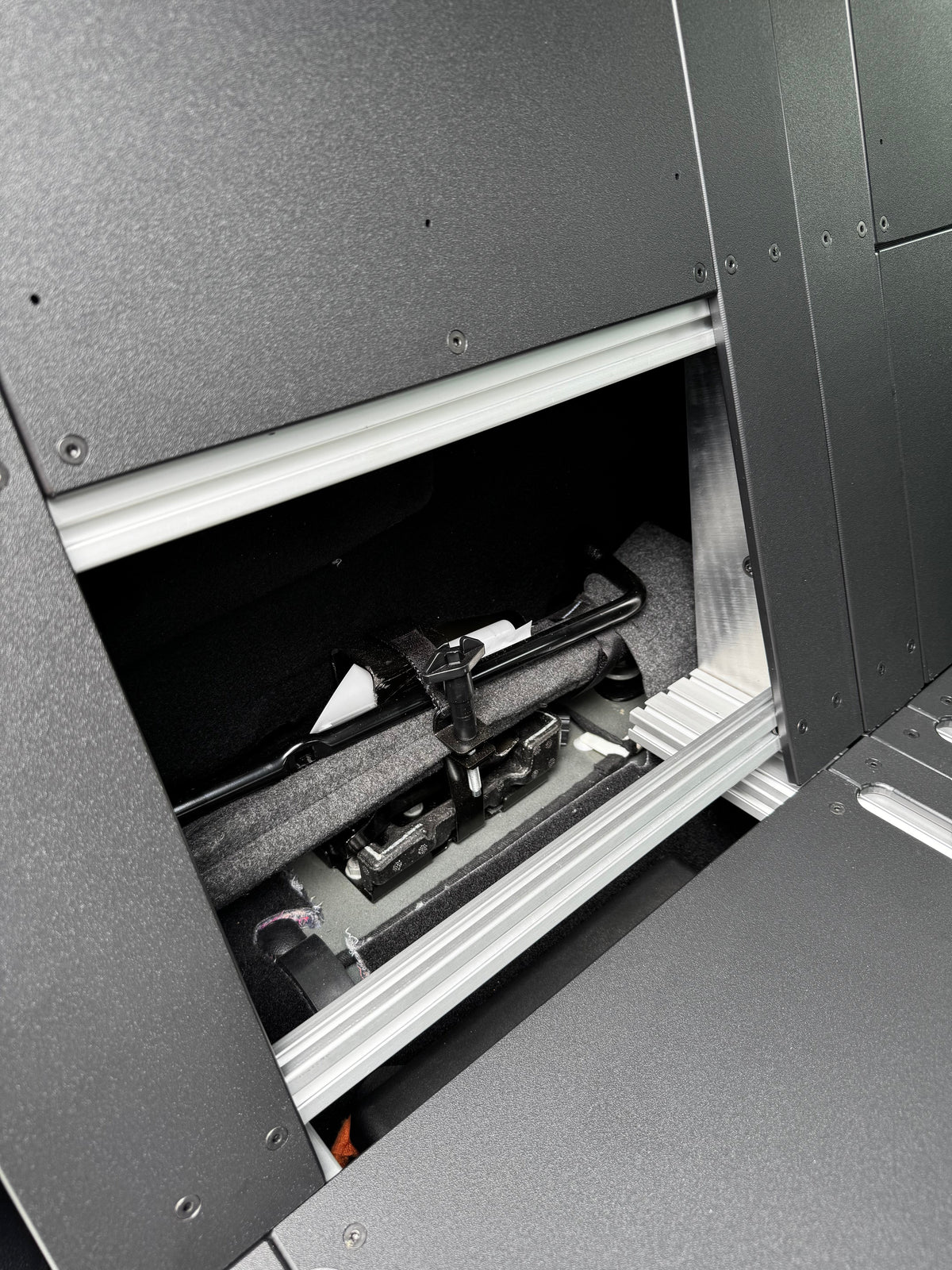 CargoKits Rear Seat Delete in a Ford F-Series SuperCrew, close-up of an access hatch handle on the platform
